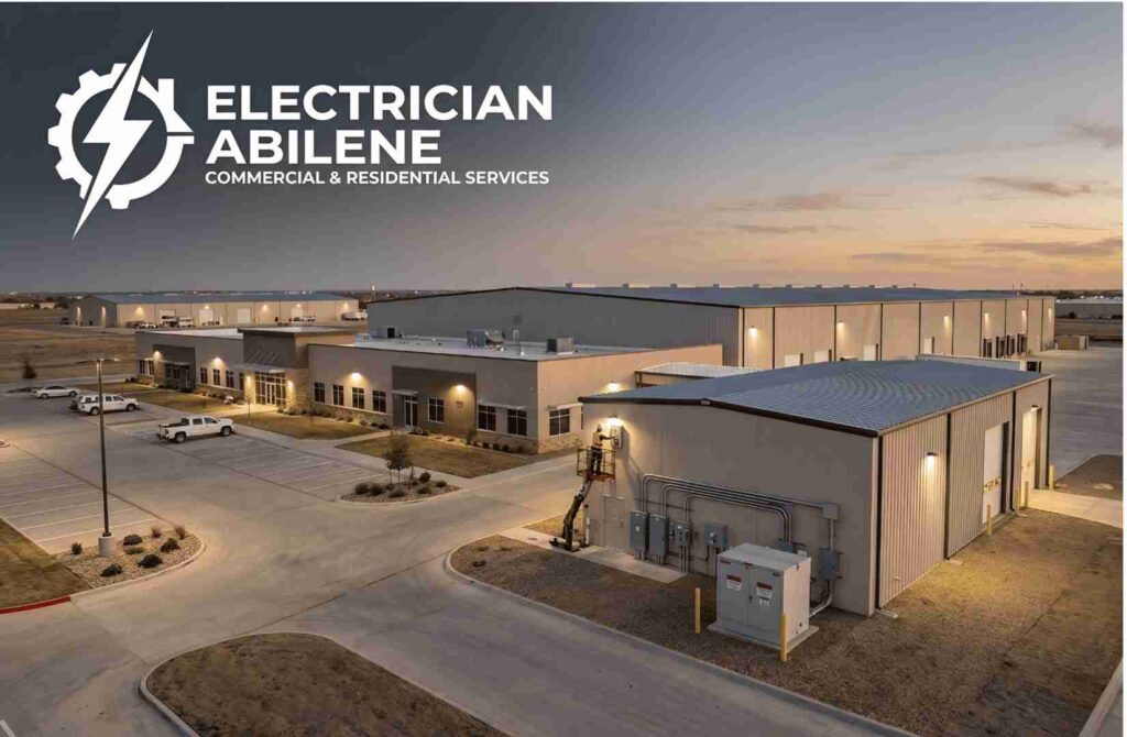 Aerial view of a commercial office and warehouse complex at sunset with the Electrician Abilene logo and text in the top-left corner.
