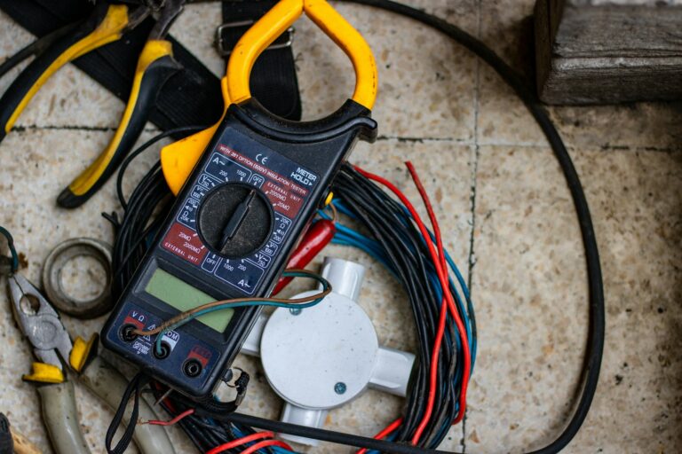 Clamp meter, pliers and electrical wire on a work surface