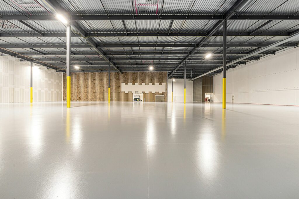 Empty warehouse lit by overhead LED high bay lights