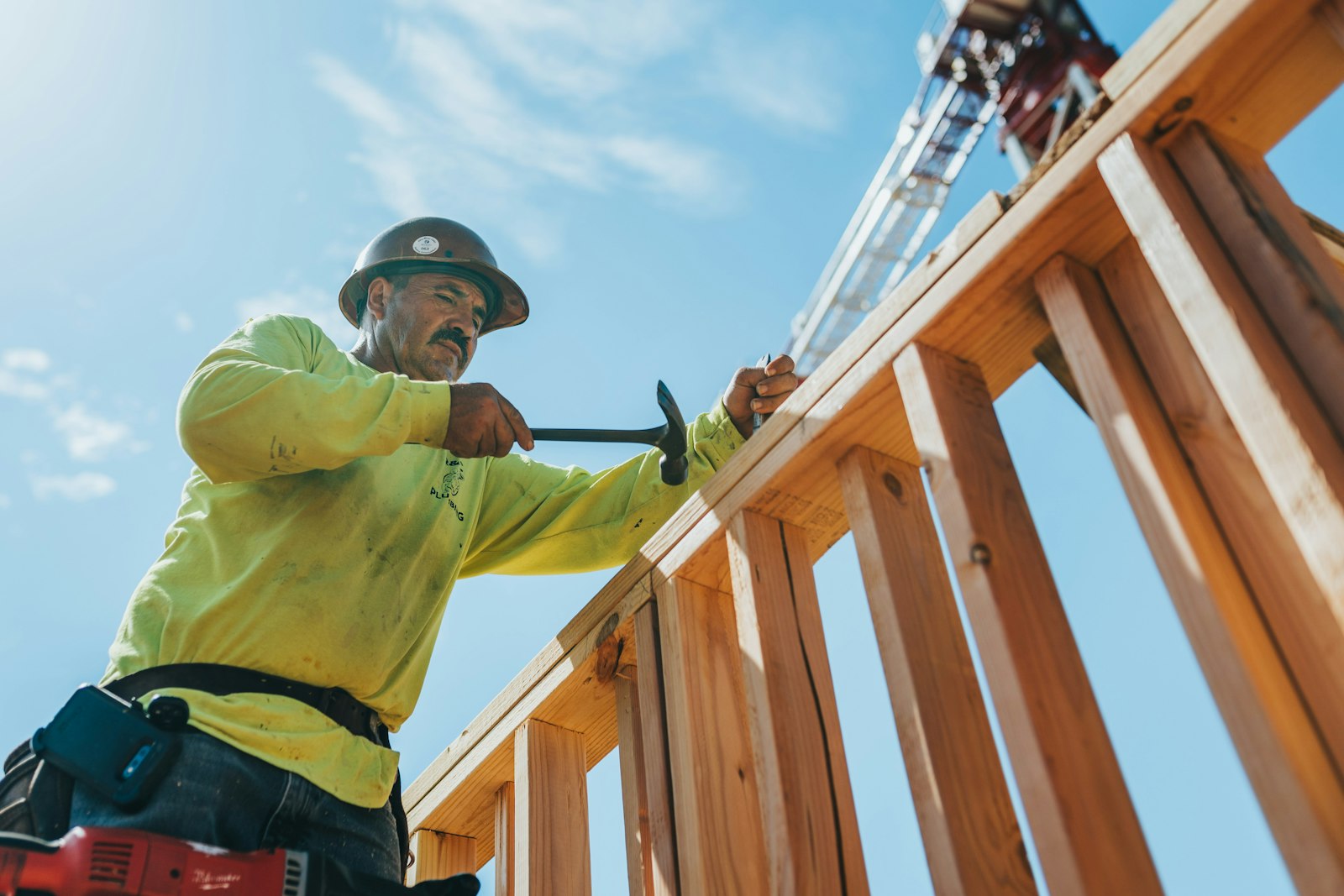 Construction worker in a hard hat framing a new building - Electrician Abilene - Electrician Abilene Construction worker in a hard hat framing a new building